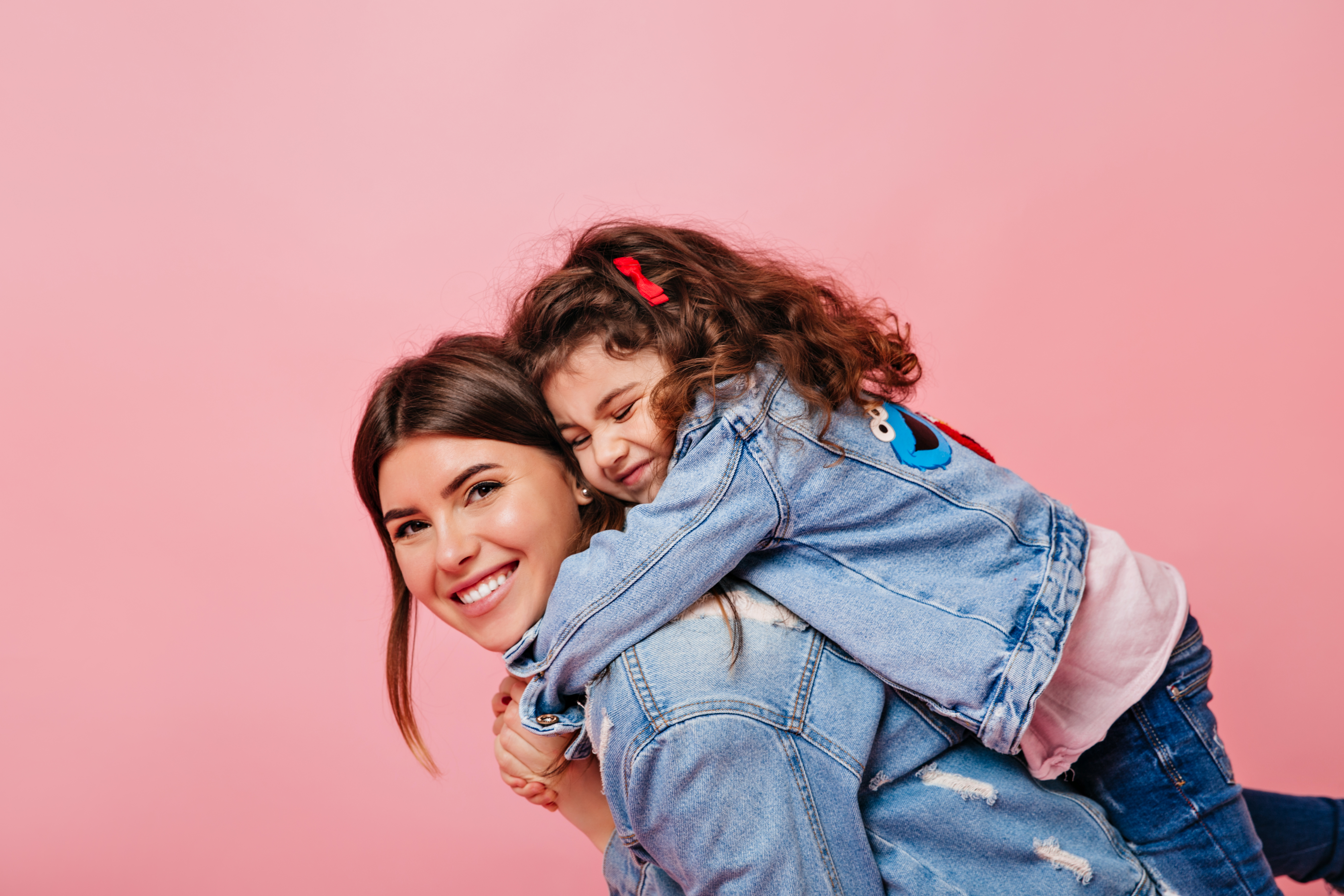 pretty-woman-carrying-daughter-piggyback-studio-shot-laughing-yong-mother-kid-isolated-pastel-background
